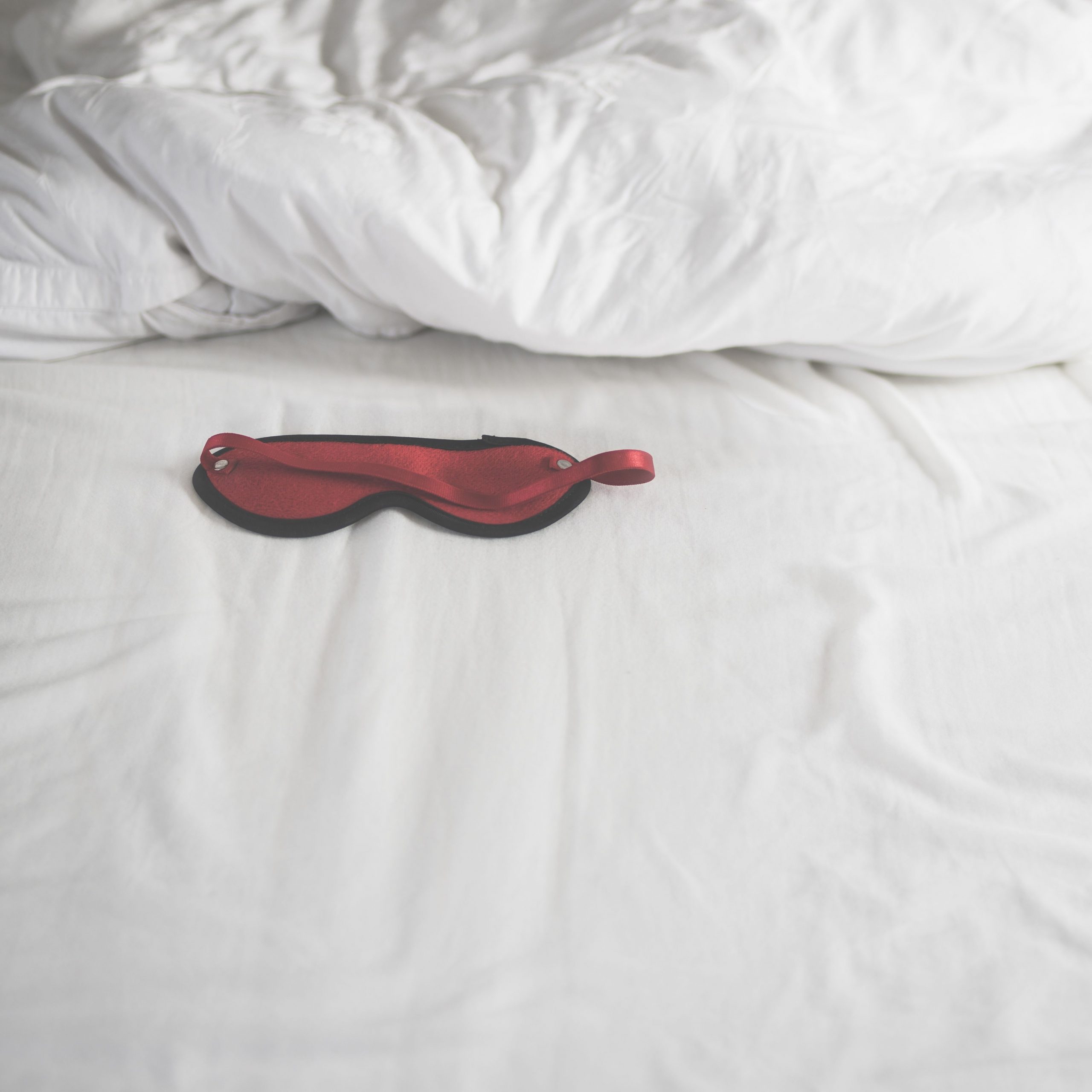 eye mask in rumpled bed